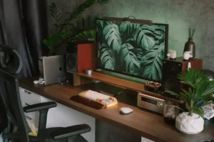 Biurko drewniane z monitorem, laptopem i roślinami w nowoczesnym home office.