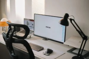 Minimalistyczne biurko z monitorem i lampka na biurko w czarnym kolorze