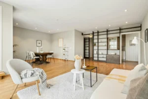 Krzesło beżowe z czarnymi nogami w jadalni; jasny salon z drewnianą podłogą i beżowym fotelem akcentowym.