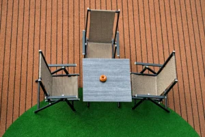 Nowoczesne krzesła ogrodowe składane z szarego materiału, ustawione na tarasie z deski kompozytowej, widok z góry.